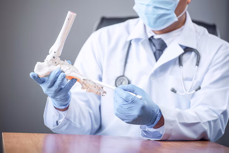 orthopedic-doctor-looking-fake-ankle-bone-male-doctors-orthopedic-wears-medical-masks_1048944-22182466